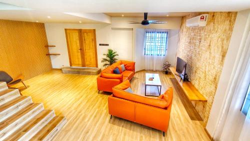 a living room with two orange chairs and a fireplace at JB City Villa (Private Pool) in Johor Bahru