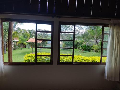 a window with a view of a park through it at Pousada Recanto da Grande Paz in Alto Paraíso de Goiás