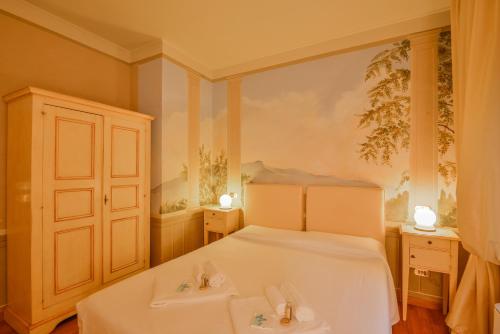 a bedroom with a white bed and two tables at Albergo San Martino in Lucca