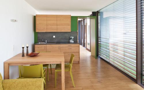a kitchen and dining room with a wooden table and chairs at Appartements Kortscherhof in Silandro