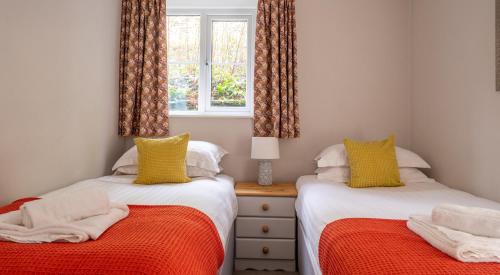 two twin beds in a room with a window at Bassenthwaite in Sawrey