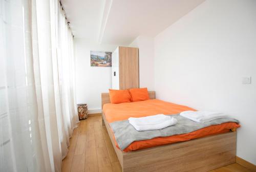 a small bedroom with a bed with orange sheets at Cozy Apartment with Mountain View & Parking in Sofia