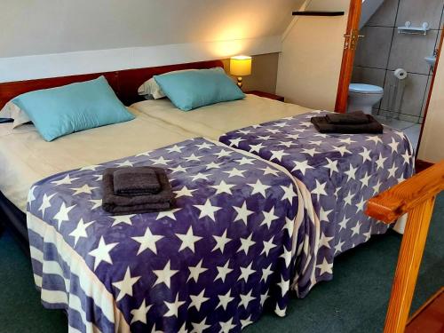 ウースターにあるSuites on 74のアメリカ旗のベッドカバーが備わる客室のベッド2台分です。