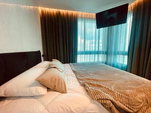 a bedroom with a bed with pillows and a window at C Tower Premium Apartments, Panoramic Sea View in Netanya