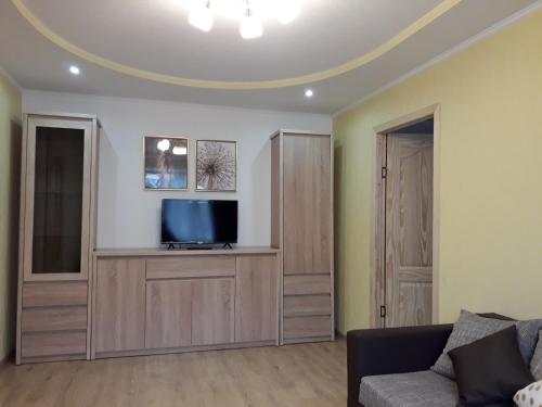 een woonkamer met een tv en een bank bij Кандавас 9 in Daugavpils