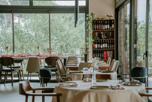 a restaurant with tables and chairs and a large window at Çiy Restaurant & Konukevi in Kusadası