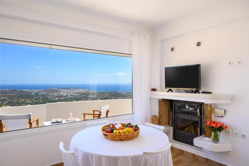 a living room with a table with a bowl of fruit at Althea Villa by breathtaking view in Agios Nikolaos