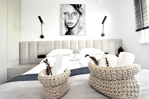 a bedroom with a bed with two baskets on it at Apartamenty Blanca in Łeba