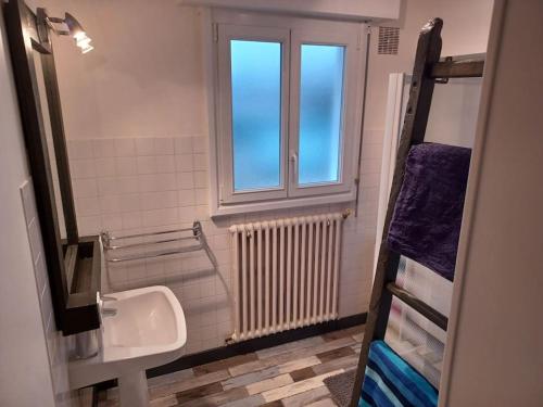 La salle de bains est pourvue d'un lavabo et d'une fenêtre. dans l'établissement Maison chaleureuse, gîte pour famille, amis, ouvriers..., à Château-Gontier