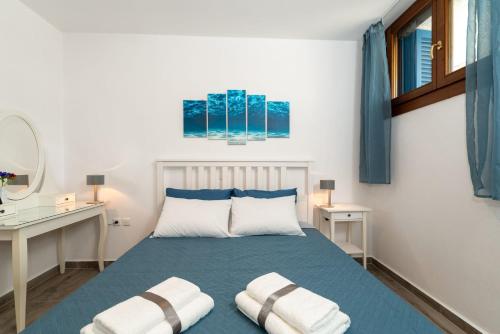 a bedroom with a blue bed with two pillows at Olivia's Countryside House in Krotiri