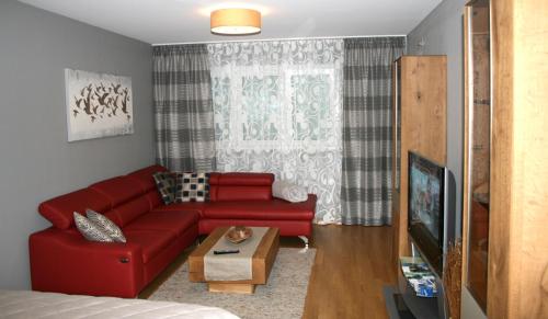 sala de estar con sofá rojo y mesa en Exklusive Familienapartment Alpin, en Garmisch-Partenkirchen