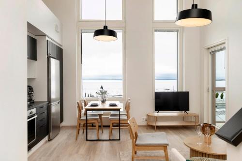 a kitchen and dining room with a table and chairs at Näsijärvi lakeview apartment in Tampere