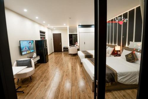 een hotelkamer met een bed, een bureau en een bank bij The One Hotel in Hai Phong