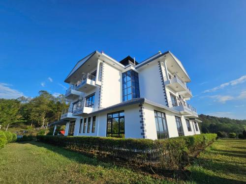 ナガルコットにあるHotell Hill Crownの青窓のある広い白い家