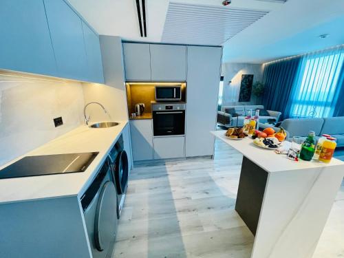 a kitchen with white cabinets and a counter with a sink at C Tower Premium Apartments, Panoramic Sea View in Netanya