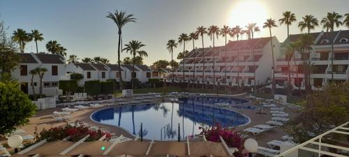 a view of a pool at a resort with palm trees at Santiago 2 Las Americas duplex 2 Dormitorios in Playa de las Americas