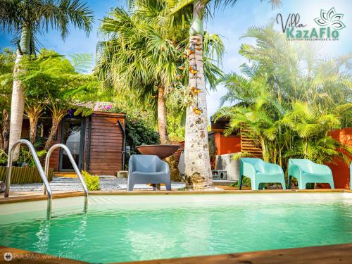 uma piscina com cadeiras e uma palmeira em La villa KazAFlo Piscine, jacuzzi, SPA, brasero em Saint-Joseph