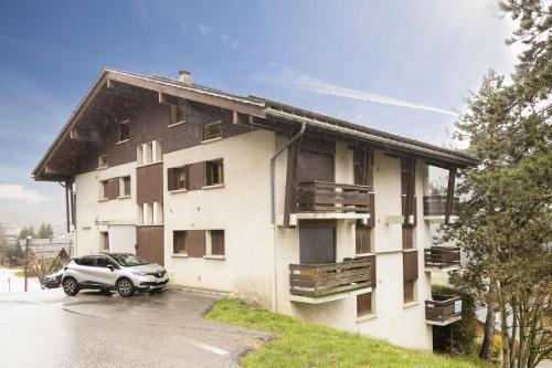 a building with a car parked in front of it at studio lumineux La Tournette in Le Grand-Bornand