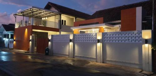 a white fence in front of a house at Alexandria12 Guest House in Selong