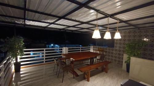 a patio with a wooden table and chairs and lights at Alexandria12 Guest House in Selong