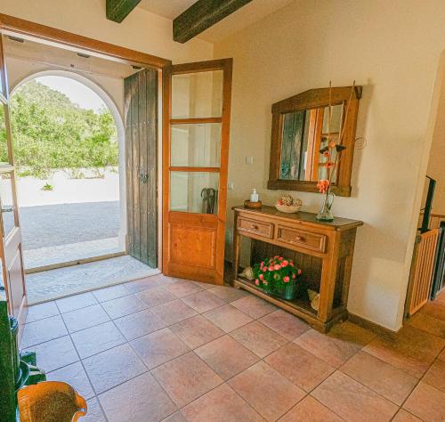 una stanza con specchio, tavolo e porta di Sa Sinia - Family rural house with pool and mountain views a S'Horta