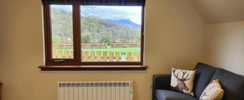 a living room with a window with a view of a golf course at Bunroy Park in Fort William