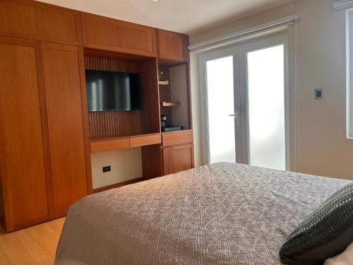 a bedroom with a bed and a tv in a cabinet at Habitación privada con baño in Lima