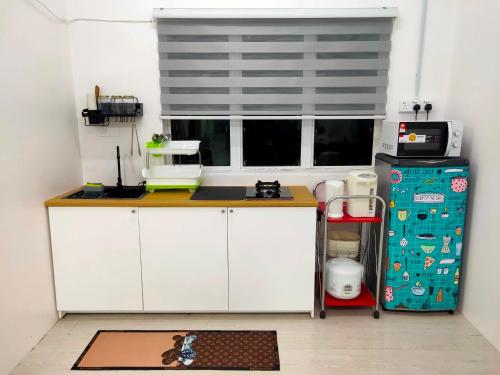 a kitchen with a white counter and a window at SALAM Homestay D'Gerik in Gerik