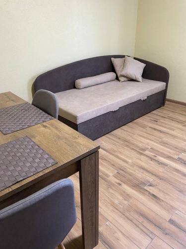 a couch in a living room with a wooden floor at Yellow apartments in Boryspilʼ