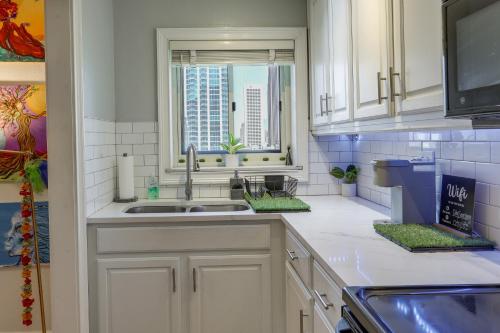 cocina con armarios blancos, fregadero y ventana en Colorful Atlanta Vacation Rental - Walk to Dtwn!, en Atlanta