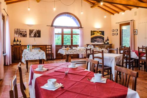 a dining room with tables and chairs and a large window at Agriturismo biologico Bulichella in Suvereto