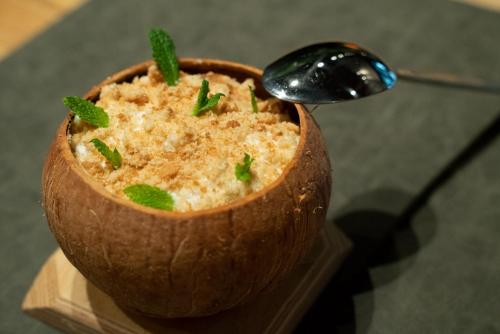 a wooden bowl of food with a spoon in it at Bilder Boutique Hotel in Bilbao