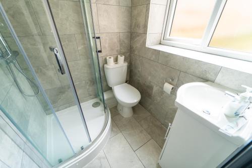 een badkamer met een douche, een toilet en een wastafel bij Spacious studio near city centre! in Birmingham
