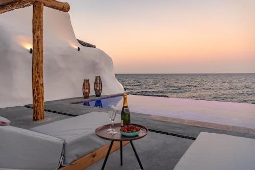 a table with a bottle of wine and a glass at Casa di Mare Luxury Villas in Imerovigli