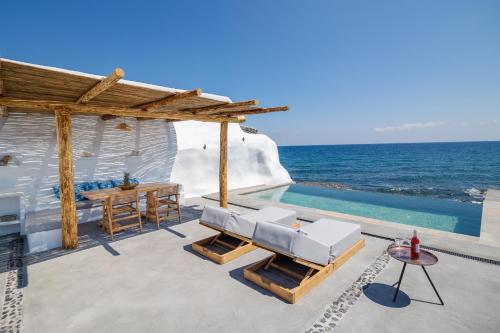 a villa with a swimming pool next to the ocean at Casa di Mare Luxury Villas in Imerovigli