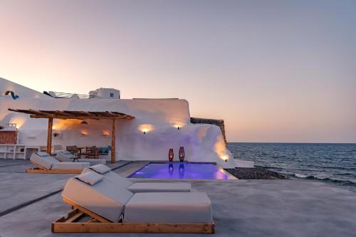 a villa with a swimming pool next to the ocean at Casa di Mare Luxury Villas in Imerovigli