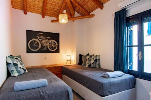 a bedroom with two beds and a bike on the wall at Koroneia Residence in Koroni