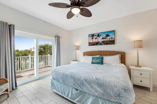 a bedroom with a bed and a balcony at Beachy Dreams in Pensacola Beach
