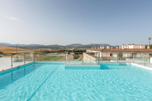 a large swimming pool with blue water at Apartamentos Martalia Áticos Deluxe in Ronda