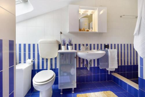 a blue and white bathroom with a toilet and a sink at Mansarda di Ponente in Caorle