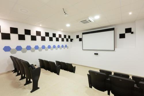 una sala de conferencias con sillas negras y una pantalla en Apartamentos Martalia Áticos Deluxe, en Ronda