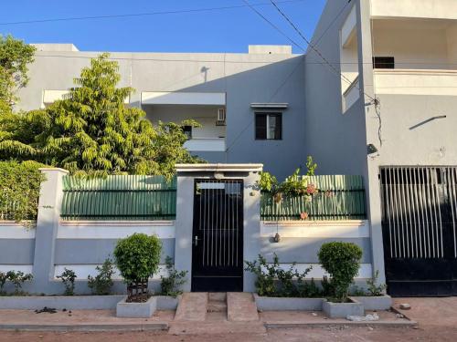 a blue and white house with a black door at Le TOUNKARANKE residence FASSO KANU- villa- 4 chambres installations solaires in Bamako