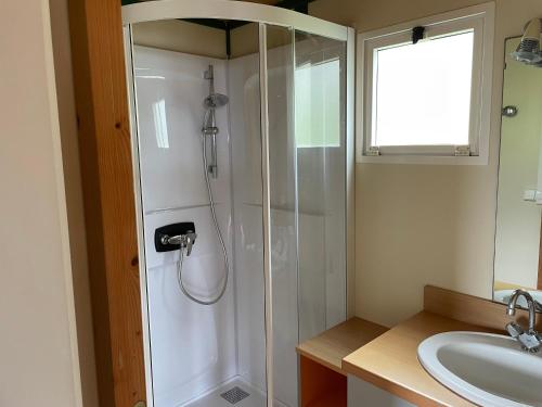 La salle de bains est pourvue d'une douche et d'un lavabo. dans l'établissement La vallée, à Belvédère