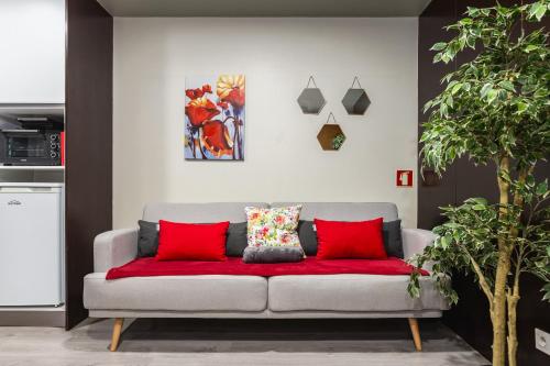 a couch with red cushions in a living room at Hopstays - Gaia Cork House in Vila Nova de Gaia