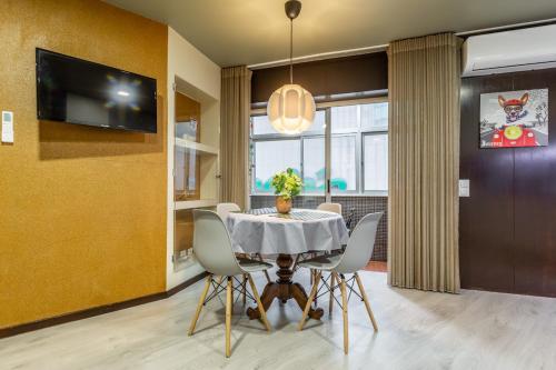 a dining room with a table and chairs and a tv at Hopstays - Gaia Cork House in Vila Nova de Gaia