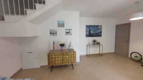 a living room with a table and a staircase at La Dimora del Salento in Torre Lapillo