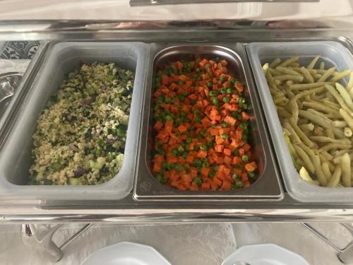 a tray of food with vegetables and french fries at Moris Boutique Beach Hotel in Gdańsk