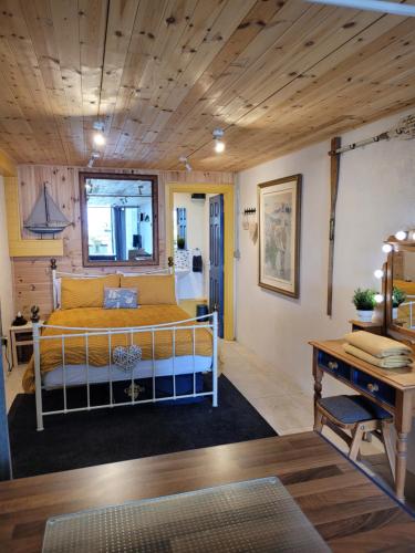 a bedroom with a bed with a wooden ceiling at The Old Boat House in Carlingford