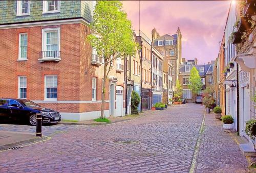 a cobblestone street in a city with buildings at GARDEN Flat in Posh MEWS in London