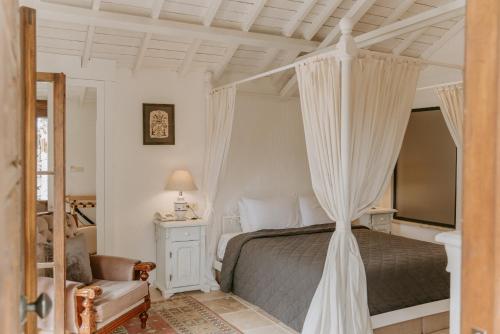 a bedroom with a canopy bed and a chair at Çiy Restaurant & Konukevi in Kusadası
